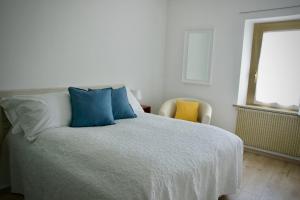 布亚B&B The Secret Garden的一间卧室配有一张带蓝色枕头的床和一扇窗户。