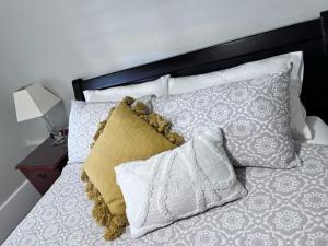 阿德莱德Penzance Cottage的一张带黑白床头板和枕头的床