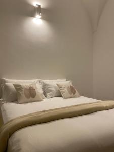 马奥莱LA CASA DI SASA'的一张带白色枕头的床和墙上的灯