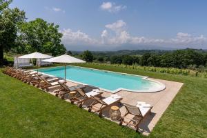 PiglioAl Piglio Maison de Charme Wine & Wellness Resort的一个带躺椅和遮阳伞的游泳池
