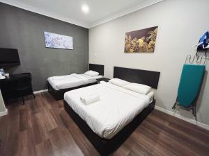 Kampong Tanjong GelamMelur Inn, Tok Jembal的客房设有两张床和一张书桌