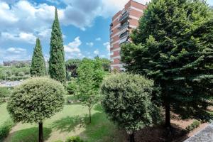 罗马RESIDENZA ERES EUR的公园里一群树木,有一座建筑