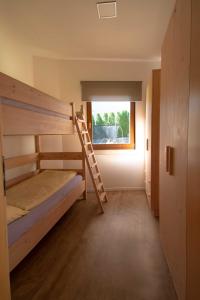 卡尔达罗Melanies Guesthouse 2 Zimmerwohnung的一间卧室配有一张双层床和梯子
