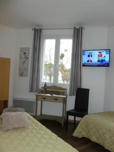 巴讷维尔-卡特里特泽西岛酒店的一间卧室配有书桌,窗户配有电视