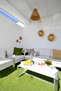 阿吉内金海滩Luminoso loft recién reformado的客厅配有白色家具和绿色地毯
