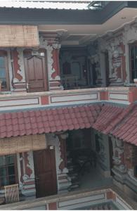 乌布Banana Home Stay Ubud的一座带红色屋顶和阳台的古老建筑
