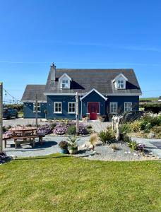 海上费萨德Thistledown Lodge的院子里有红色门的蓝色房子