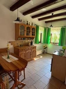 RzeczkaDom w Rzeczce Góry Sowie的厨房配有绿色窗帘和木桌