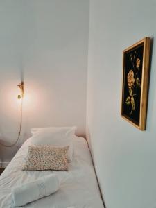 SoyonsLa Gare Soyons的一张带枕头的白色床和墙上的照片