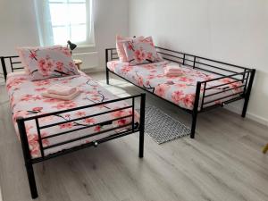 NijswillerBed & Stay Kersenbloesem的客房内的两张床和一张沙发