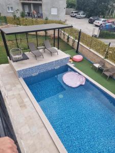 蒂瓦特Villa with Pool & Garden apartment 1 Ognjen的享有带椅子的游泳池和凉亭的顶部景致