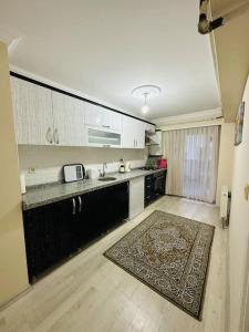 恰纳卡莱Ak Home Dublex - apartment的厨房配有柜台和地板上的地毯