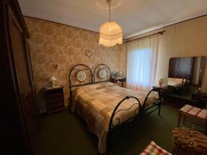 FaidelloCasa Matteoli的一间卧室配有一张床和一个吊灯