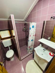 库伦瓦库夫Unaqua Apartments的粉红色的浴室设有卫生间和水槽