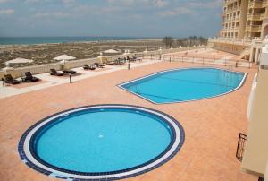 拉斯阿尔卡麦Amazing sea view studio的海滩旁的大型游泳池