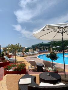 Sidhirokhórion罗家斯酒店的一个带桌椅和遮阳伞的游泳池