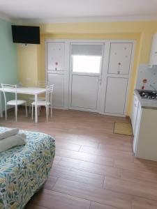 CesiomaggioreColori nel Parco 2的客房设有厨房和带床的桌子。