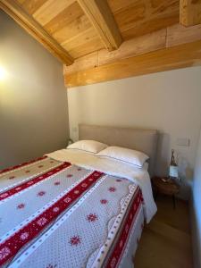 利莫内皮埃蒙特Alpi Azzurre的一间卧室配有一张带红白色棉被的床