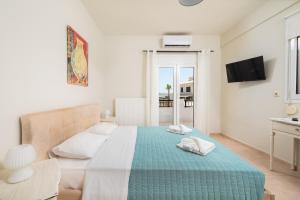 赫索尼索斯Villa Sophia-Elpis的白色卧室配有一张带蓝色毯子的床