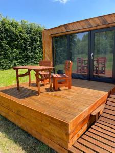ZátorObytný kontejner Cabin Stars的木制甲板配有野餐桌和椅子