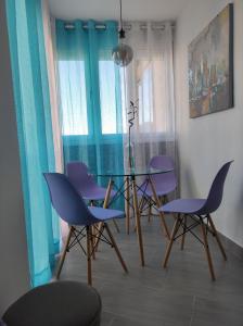 托罗克斯科斯塔Estudio El Faro II的一间用餐室,配有紫色椅子和玻璃桌