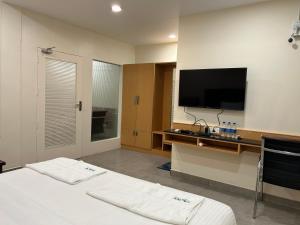 卡努尔KKM Highlands的一间卧室配有一张床和一台平面电视