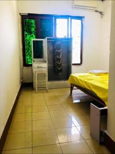 万象Vernice Backpacker Hostel的客房铺有瓷砖地板,设有1张床和电视。