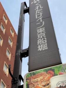 东京东京船堀吴竹酒店的建筑物旁边的柱子上的标志