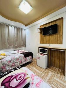 佩尼亚Pousada Cantinho das Flores的一间卧室配有两张床和一台平面电视