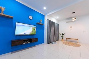 波德申No 19 Studio Homestay (Semi-D), Port Dickson (up to 13 pax)的客厅设有蓝色的墙壁和平面电视。