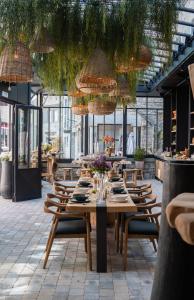 杜柏Hotel LEA - Maison Caerdinael的用餐室配有桌椅和植物
