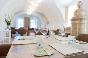 Sankt Andrä-HöchAm Pfarrhof - Gourmethotel by Harald Irka的一张木桌,上面放有酒杯