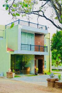 阿努拉德普勒Shanthi Villa Resort的房屋的顶部设有阳台