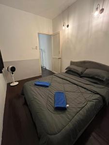 乔治市sungai ujong home stay的一间卧室配有一张大床,上面有蓝色的毛巾