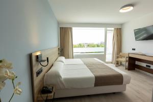 马塔拉斯卡尼亚斯弗拉梅罗酒店的配有一张床和一张书桌的酒店客房