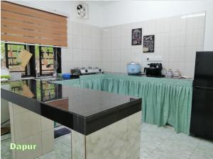 斯利姆河Kampung Vibe @ Homestay Baiduri的厨房配有带绿色台面的桌子