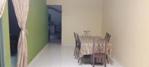 伯豪BB Bahau Homestay的绿色墙壁的客房内的桌椅