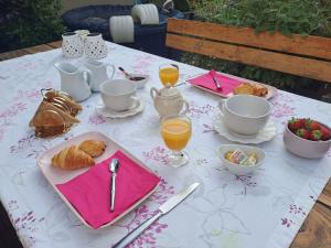 维希Chambre d'hôte des Thermes的餐桌,包括茶、羊角面包和橙汁