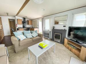 萨克斯曼德姆Beautiful Caravan With Decking At Carlton Meres Holiday Park, Suffolk Ref 60022m的带沙发、电视和桌子的客厅
