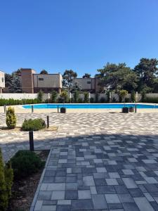 奥林普Sea View Apartments Olimp- The sunny apartment的一座石头庭院,后面设有一个游泳池