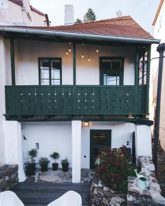 捷克克鲁姆洛夫Domeček / Tiny House的白色的房子,设有绿色阳台