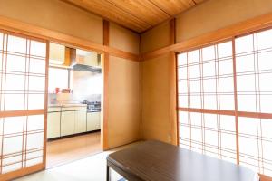南伊豆町貸別荘　満月の夜的一间带桌子和2扇大窗户的用餐室