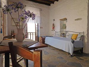 阿诺锡罗斯Philoxeno Traditional house - Ano Syros的一间卧室配有床和桌子,花瓶装有鲜花