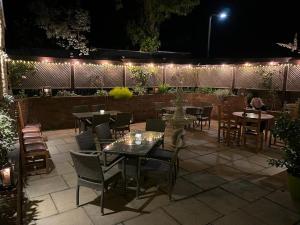 Stoke Albany白马旅馆及餐厅的庭院在晚上配有桌椅