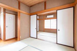 南伊豆町貸別荘　満月の夜的一个空房间,有三个门和窗户