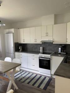 埃农泰基厄Apartment Hillankukka的厨房配有白色橱柜、桌子和炉灶。
