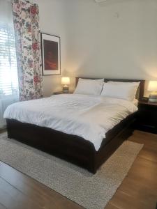Al ḨamrāʼLittle Garden private pool villa的卧室配有一张带白色床单和枕头的大床。