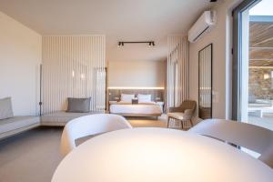 提诺斯Yenesis Seaside Retreat - Adults only的酒店客房带一张床、一张桌子和椅子