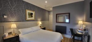 Stoke Albany白马旅馆及餐厅的一间酒店客房,配有一张白色的床和一张书桌