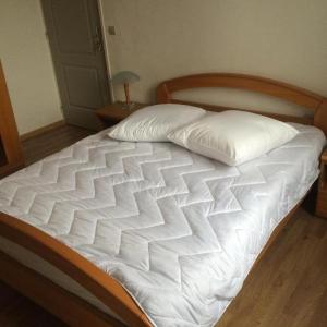 里尔HOMESTAY LILLE的一张带白色床单和枕头的床
